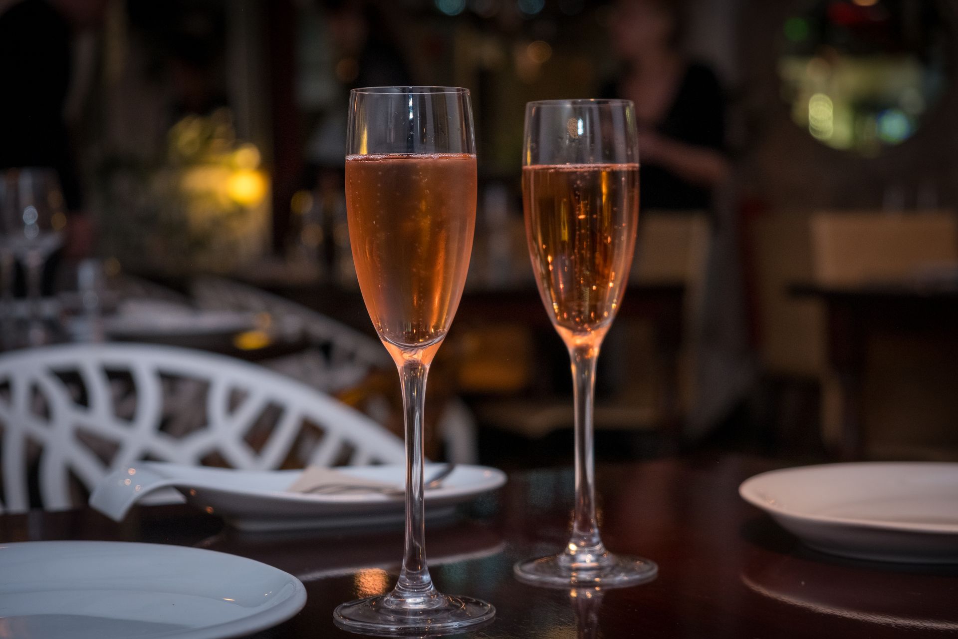 Celebración y elegancia: Brindis con vino espumoso, capturado por Boca Studio BCN Dos copas de cava rosé en ambiente de restaurante, brindis, fotografía de bebidas y ambiente en Barcelona