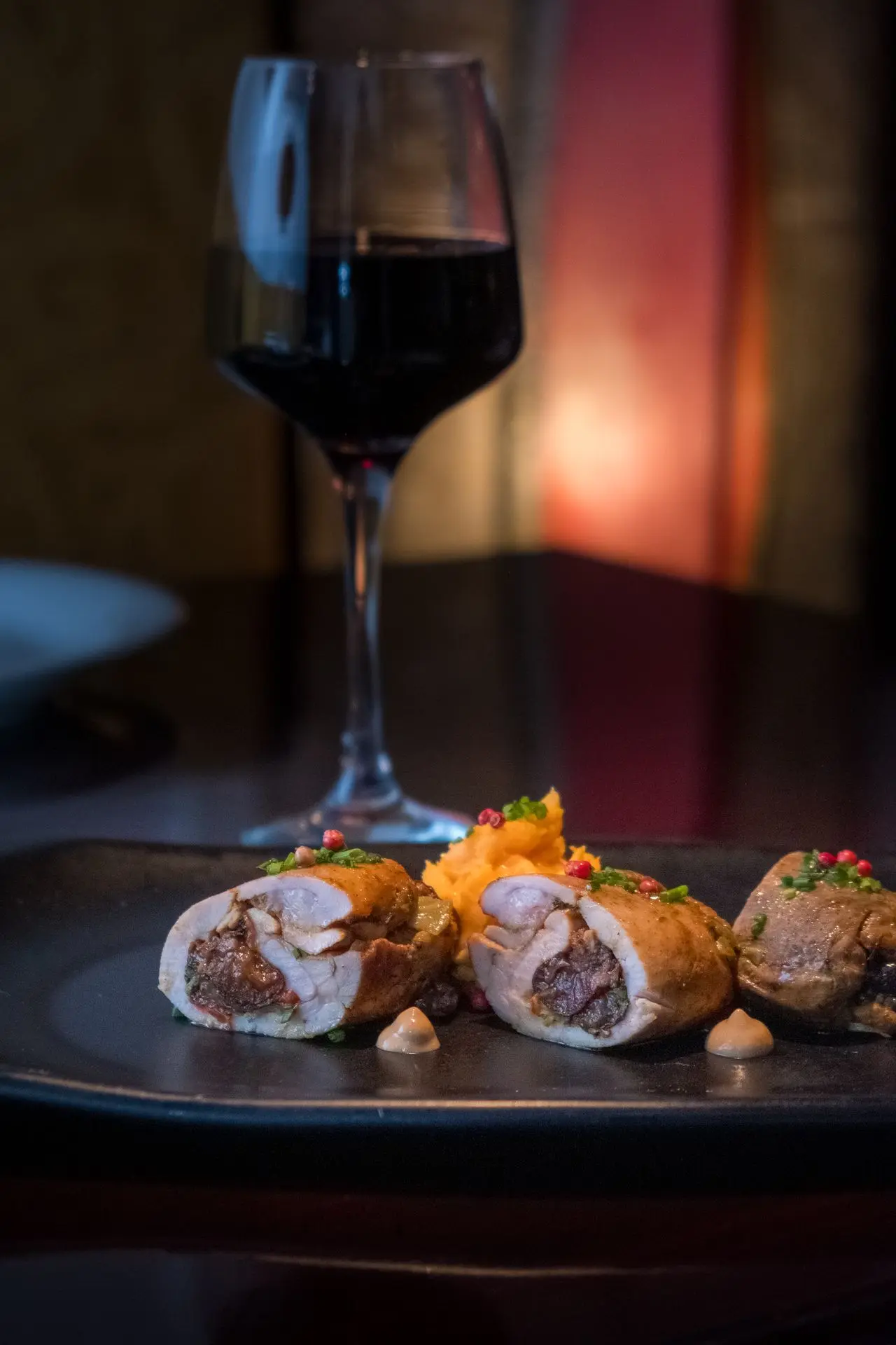 Roulés de pollo rellenos de ciruela con puré y vino tinto, plato gourmet, fotografía de alta cocina para restaurante en Barcelona