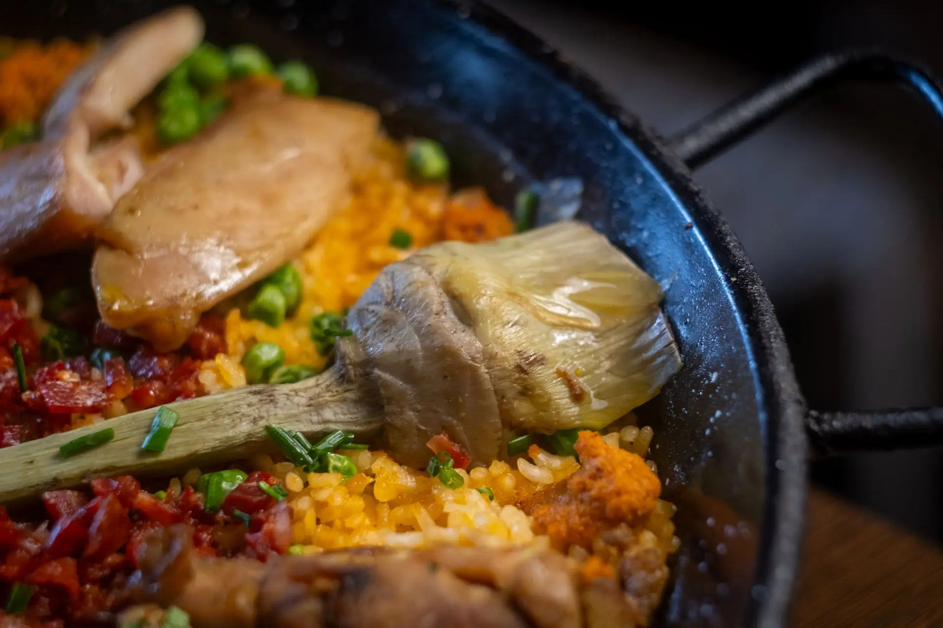 Paella valenciana con pollo, alcachofa y arroz, fotografía de cocina española tradicional para restaurante Barcelona