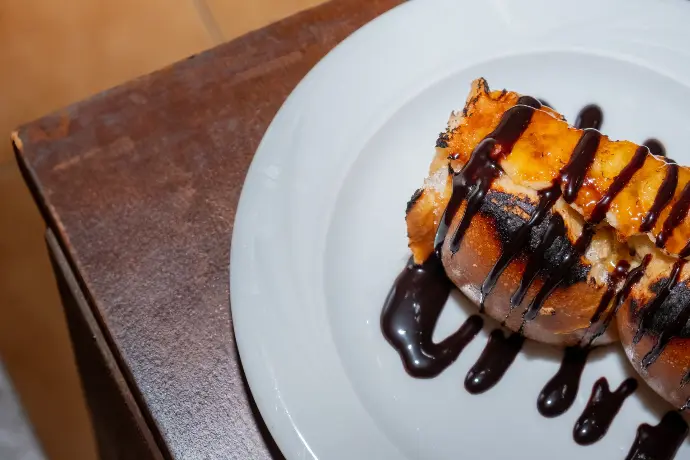 Postre de brioche perdue con sirope de chocolate, dulce artesanal, fotografía de repostería para restaurante Barcelona