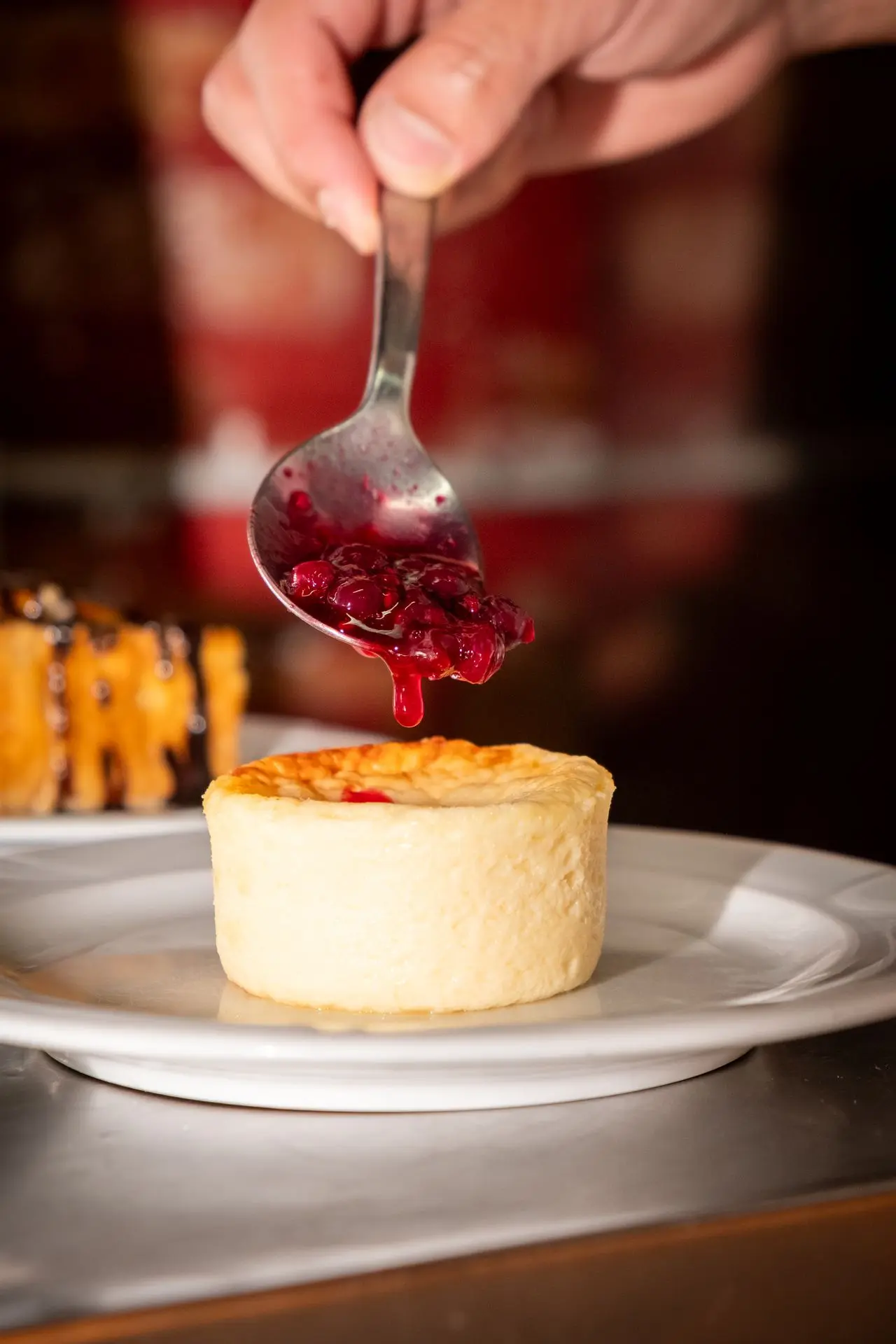 Postre individual con salsa de frutos rojos, decoración culinaria, fotografía de repostería para restaurante Barcelona