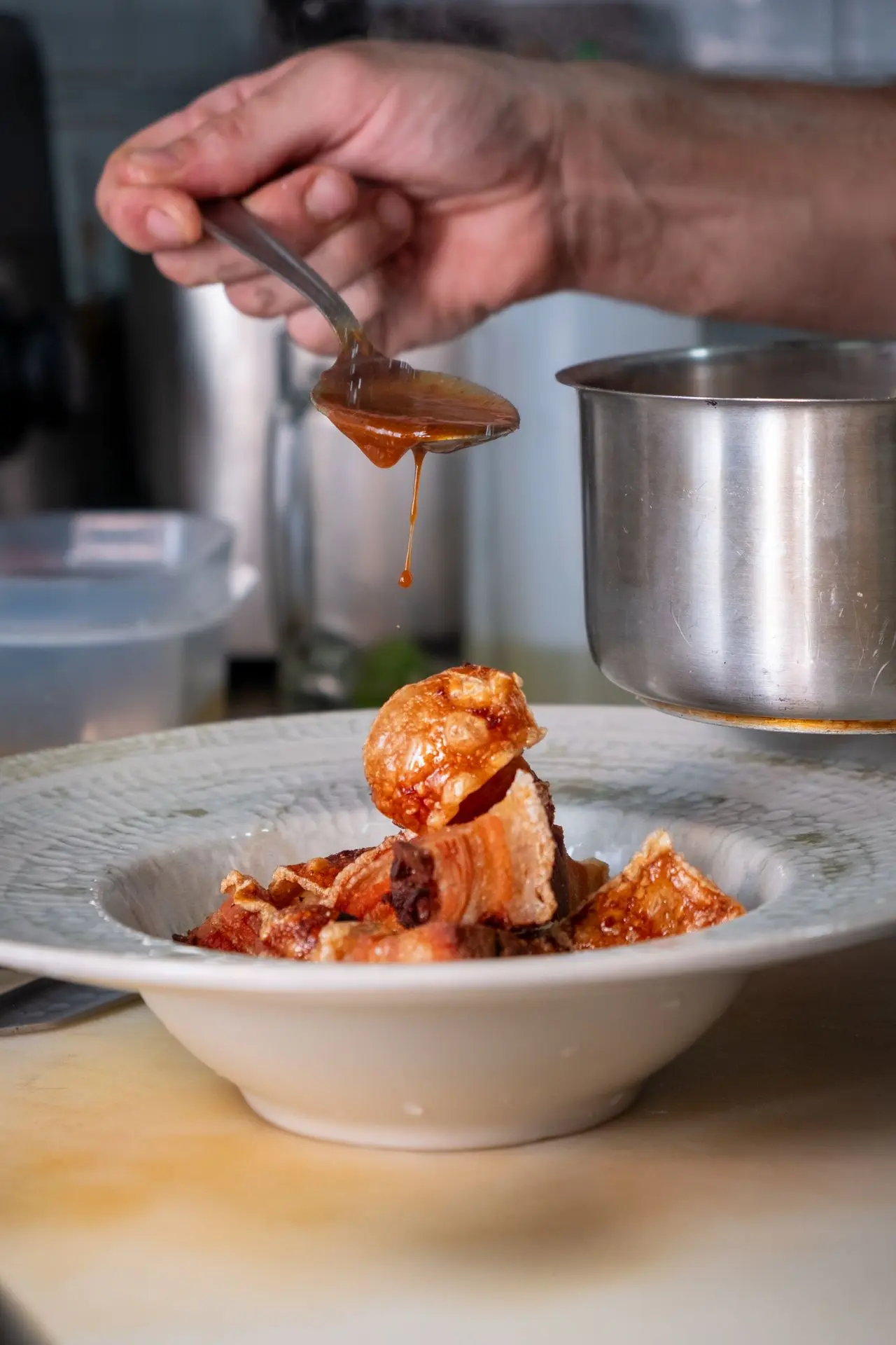 Chef salseando torreznos crujientes, tapa española gourmet, fotografía de cocina tradicional renovada en Barcelona