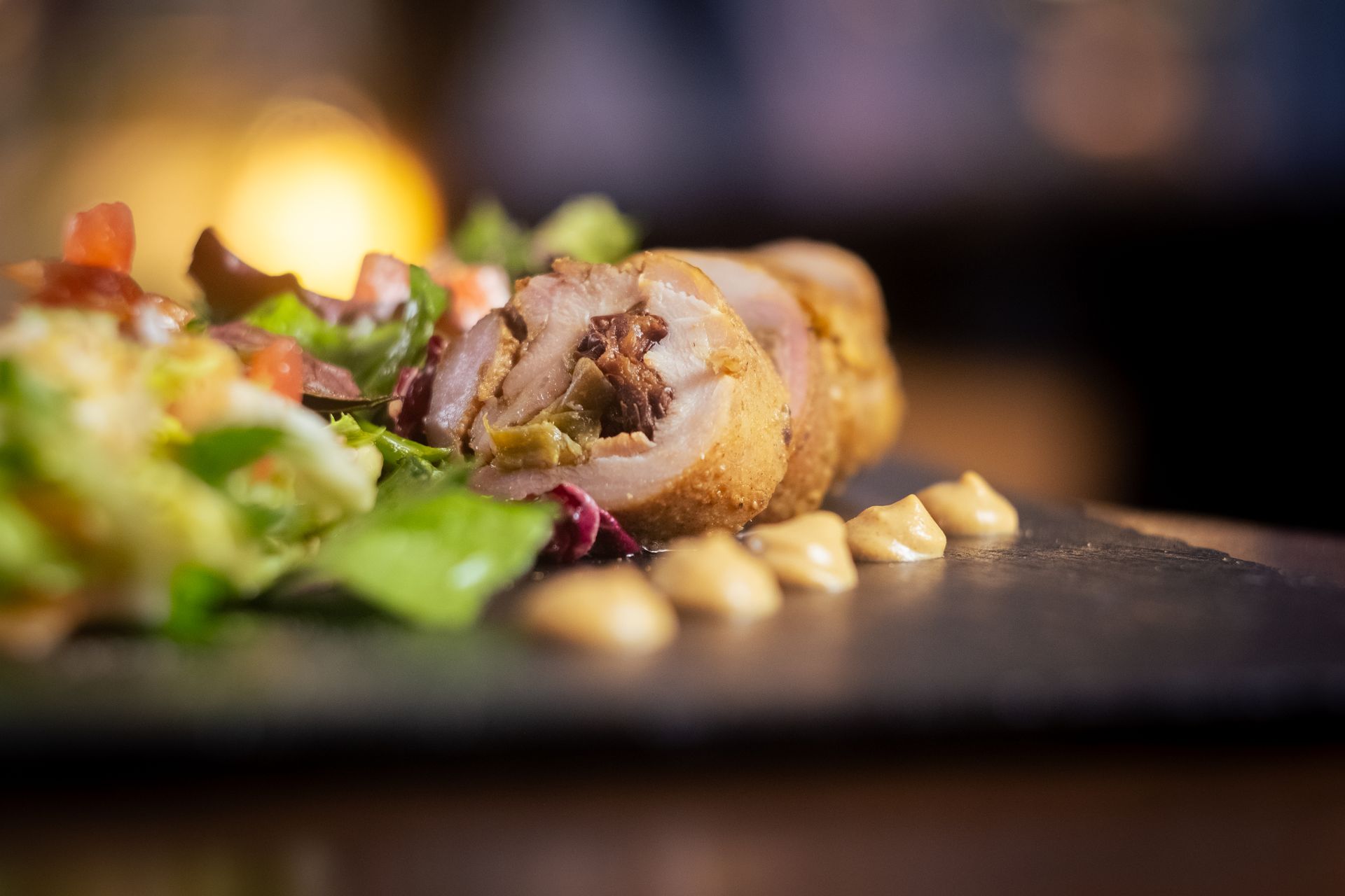 Presentación exquisita: Roulé de pollo crujiente con ensalada, el toque de Boca Studio BCN Roulé de pollo relleno de ciruela y frutos secos, con ensalada fresca, plato gourmet, fotografía culinaria en Barcelona
