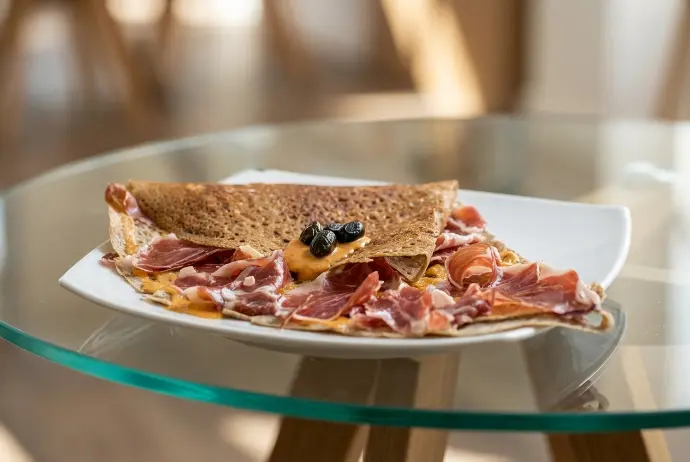 Foto profesional gastronómica de crepe de jamón ibérico creada por IA para restaurante